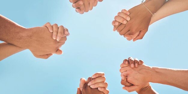 Image-1.jpg Mains entrelacées sur un ciel bleu, symbolisant la solidarité.